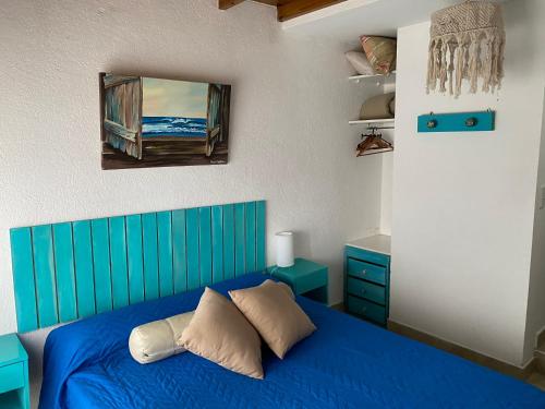 een slaapkamer met een blauw bed en een raam bij Complejo Noi Alaia in Valeria del Mar