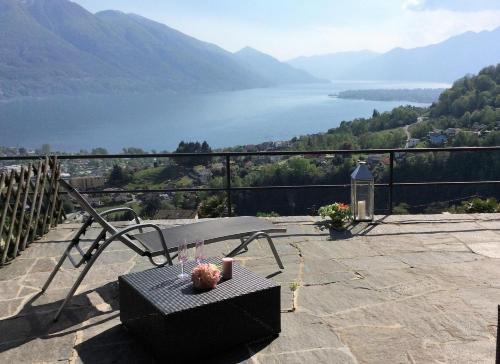 a table and chairs on a patio overlooking a lake at Casa Sopralago by Fewotessin in Gordevio