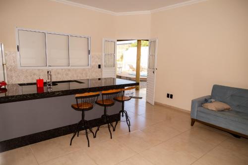 a kitchen with a bar with stools and a couch at Espaço Hórus in Socorro
