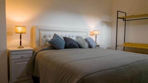 a bedroom with a large bed with two lamps at Balcon de la virgen in Luján