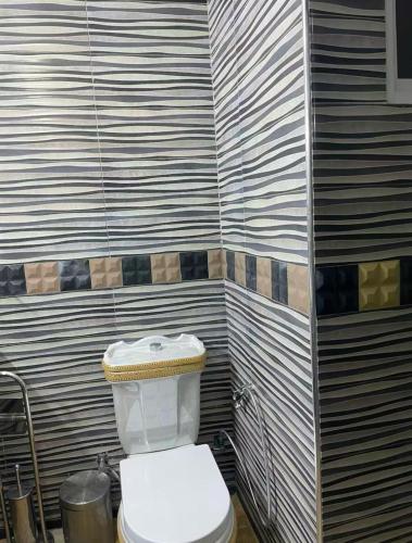 a bathroom with a white toilet in a room at Apartment in martil in Martil