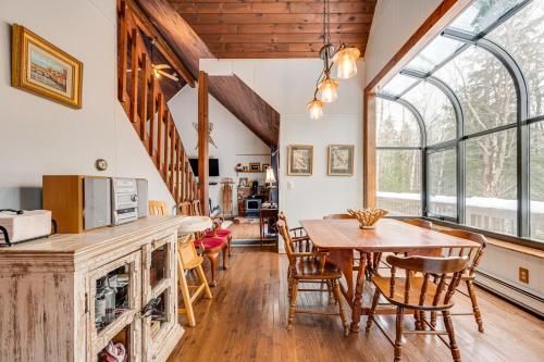 a kitchen and dining room with a table and chairs at Rustic Intervale Hideaway with Deck and Wooded Views! in Intervale