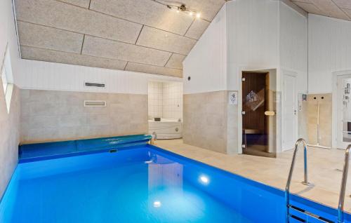 a large bathroom with a swimming pool in a room at Beautiful Home In Væggerløse With Sauna in Marielyst