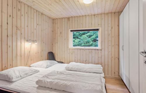 a bedroom with a bed in a wooden wall at Beautiful Home In Væggerløse With Sauna in Marielyst