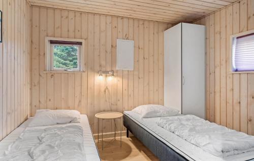 a bedroom with two beds and a table in it at Beautiful Home In Væggerløse With Sauna in Marielyst