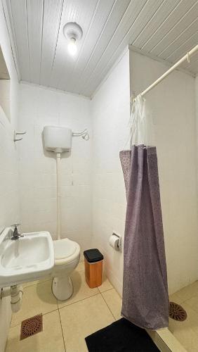 a bathroom with a sink and a toilet at Atlantida Johsil Hotel in Xangri-lá