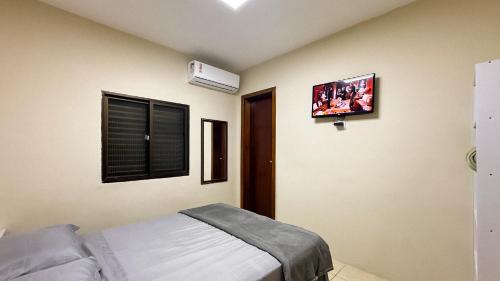 a bedroom with a bed and a tv on the wall at Atlantida Johsil Hotel in Xangri-lá