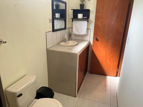 a small bathroom with a toilet and a sink at Apartment Open House in Managua