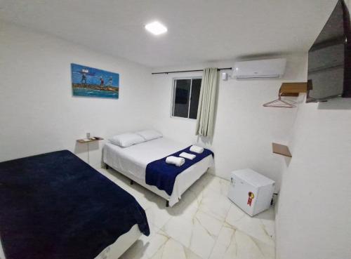 a bedroom with two beds and a window at Pousada Villa Margarida in Búzios