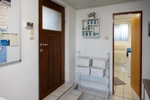 a hallway with a door and a shelf of towels at Huus Jan in Spiekeroog
