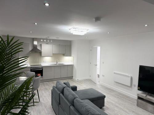 a living room with a couch and a kitchen at Serenity Waterfront 2 Bed Apartment in Northfleet