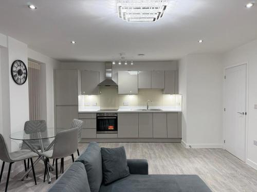 a living room with a couch and a table and a kitchen at Serenity Waterfront 2 Bed Apartment in Northfleet