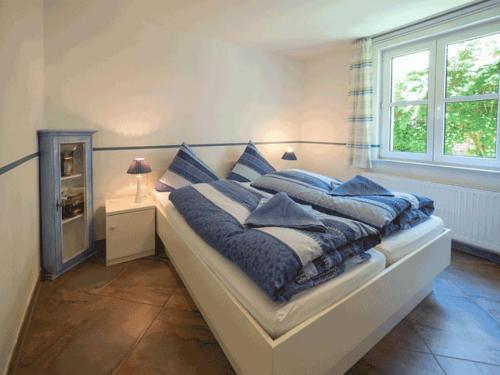 a bedroom with a bed with blue pillows on it at Pastors Tuun in Spiekeroog
