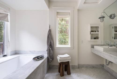 a white bathroom with a tub and a sink at Farmhouse Inn in Forestville