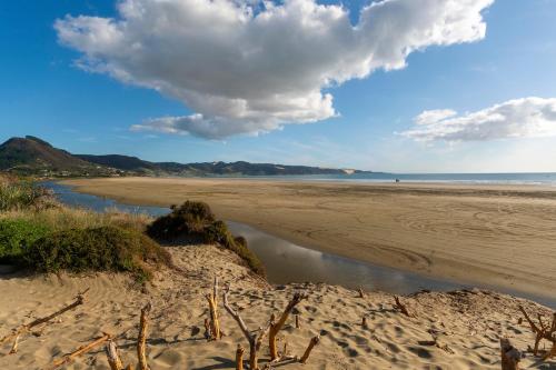 a beach with a pool of water in the sand at Ahiparadise - Ahipara Holiday Home in Ahipara
