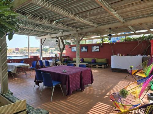 a patio with a purple table and chairs on a deck at Principauté in Gorée
