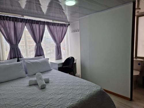 sypialnia z dużym łóżkiem z fioletowymi zasłonami w obiekcie Habitación baño privado garaje moto, Manizales w mieście Manizales