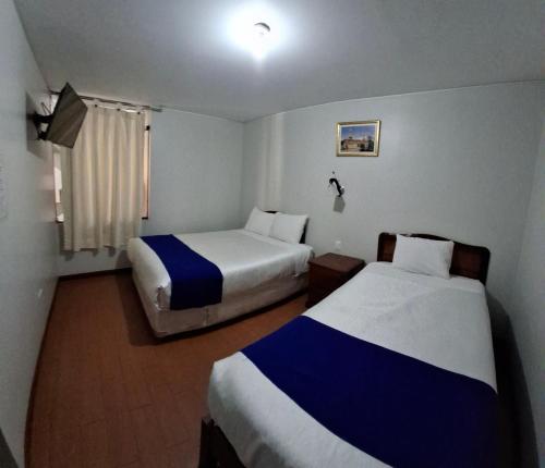 a hotel room with two beds and a window at Hotel Sideral AQP in Arequipa