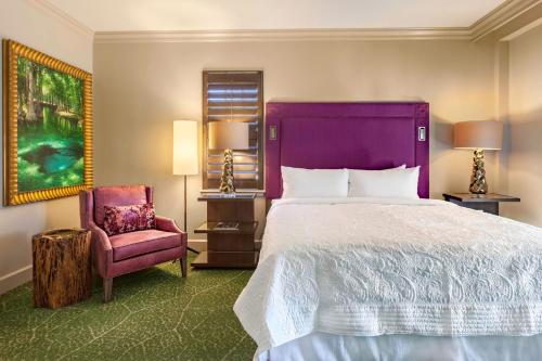 a hotel room with a large bed and a chair at Grand Bohemian Mountain Brook, Autograph Collection in Birmingham