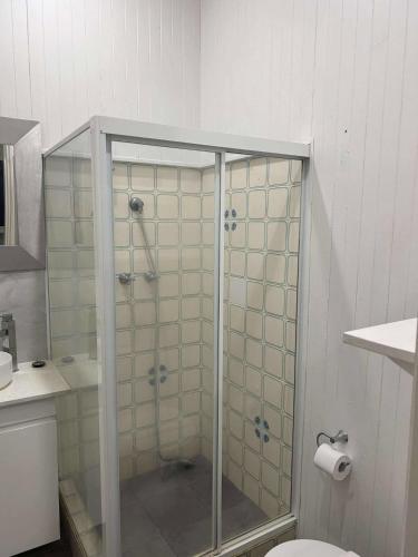 a glass shower in a bathroom with a toilet at Manly Waves Studios & Apartments in Sydney