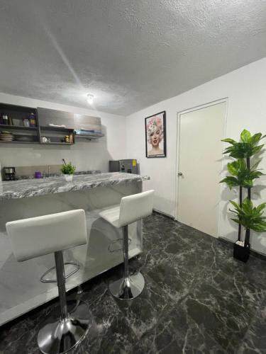 a barber shop with two white chairs and a counter at Luna House in Guadalajara