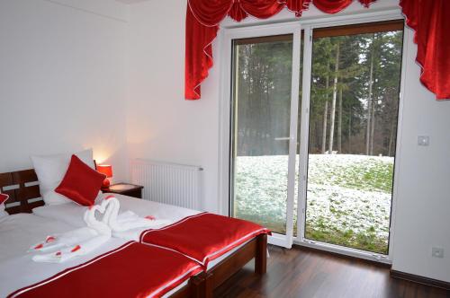 Un dormitorio con una cama y una gran puerta corrediza de vidrio. en Apartamenty Panorama, en Rychwałd