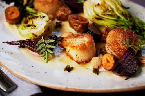 a plate of food with broccoli on a table at The Union Station Nashville Yards, Autograph Collection in Nashville