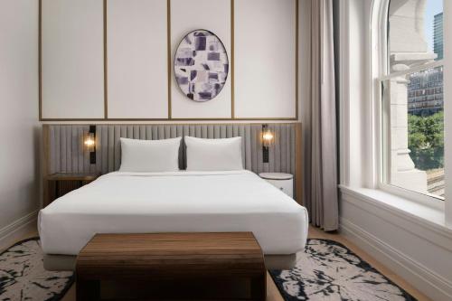 a bedroom with a large white bed and a window at The Union Station Nashville Yards, Autograph Collection in Nashville
