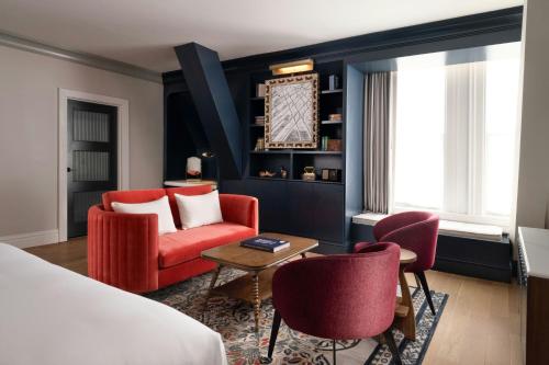 a hotel room with a bed and two chairs and a table at The Union Station Nashville Yards, Autograph Collection in Nashville