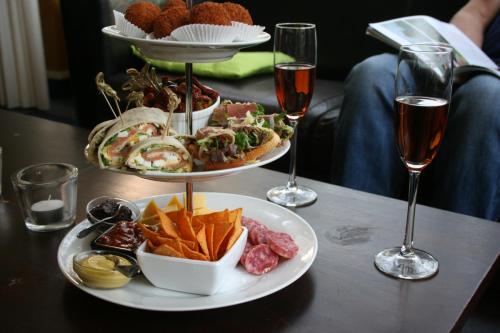 a table with two plates of food and two glasses of wine at Landgoed Ehzerwold in Almen