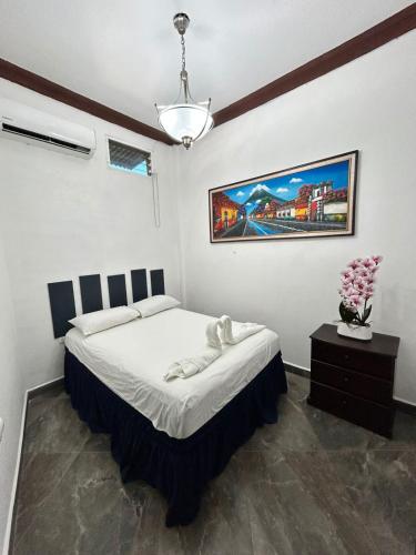 a bedroom with a bed and a painting on the wall at Hostal Casa de Grethel in Flores