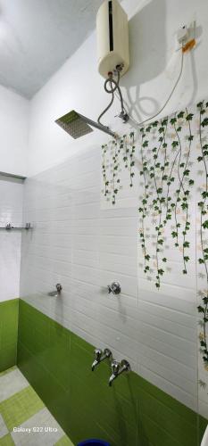 a bathroom with green and white tiles and a shower at Rams Guest House Samudra-Walk to Cliff,Odayam,Black Beach Varkala in Varkala