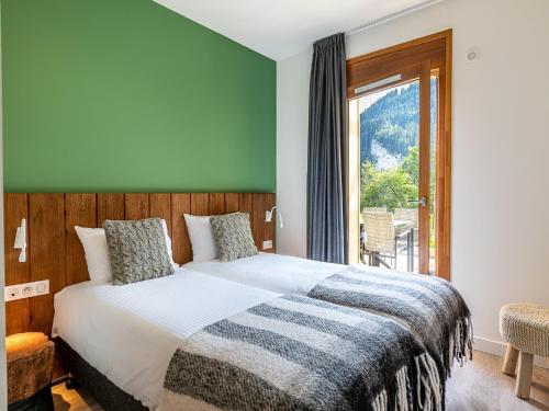 a bedroom with a bed and a large window at Chalet in French Alps with Mountain Views in Abondance