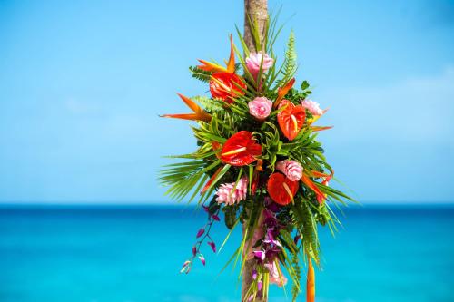 a bouquet of flowers is hanging on a tree at Waves Resort & Spa, Barbados, An Autograph Collection All-Inclusive Resort in Saint James