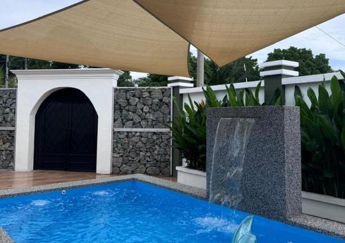 a swimming pool in a backyard with a water fountain at Tiny House Dferry With Private Pool OR 4 Room Homestay Jerantut Wifi Full Aircond in Jerantut