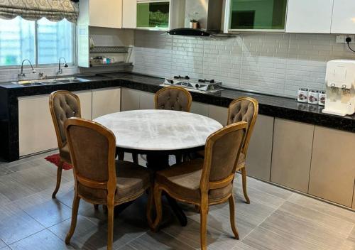 a kitchen with a table and chairs in a kitchen at Tiny House Dferry With Private Pool OR 4 Room Homestay Jerantut Wifi Full Aircond in Jerantut