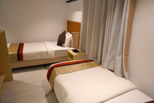 a hotel room with two beds and a window at TME Retreats Dhigurah in Dhigurah