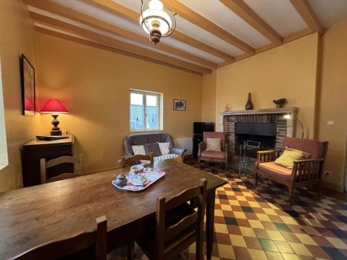 un salon avec une table et une cheminée dans l'établissement Maison de charme avec jardin clos en Sologne Bourbonnaise, animaux acceptés, près de Moulins. - FR-1-489-258, à Aurouer
