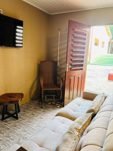 a living room with a couch and a television at Complexo Turístico Gruta da Serra in Guaramiranga