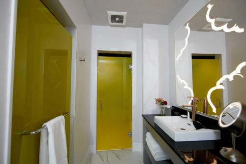 a bathroom with a sink and a yellow door at Elyton Hotel, Autograph Collection in Birmingham