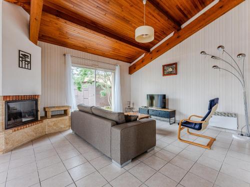 un salon avec un canapé et une cheminée dans l'établissement Maison à Biscarrosse: proche plage, commerces, jardin, terrasse avec BBQ, 5 pers, garage - FR-1-521-247, à Biscarrosse