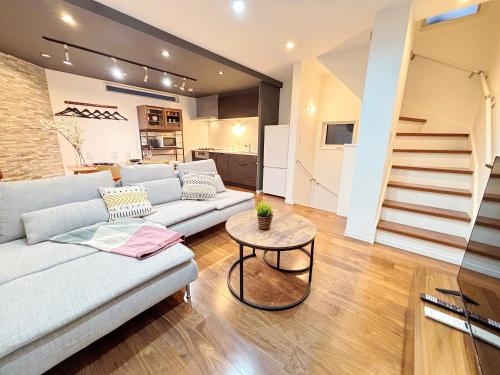 a living room with a couch and a table at Ikebukuro area, Close to Shinjuku, three layer house, Viewing terrace, 6 min walk to subway stn, 近池袋新宿 全新三层别墅有露台 地铁站步行6分 直达新宿 东京塔 哈利波特主题乐园 公交站步行3分 最大7人 in Tokyo