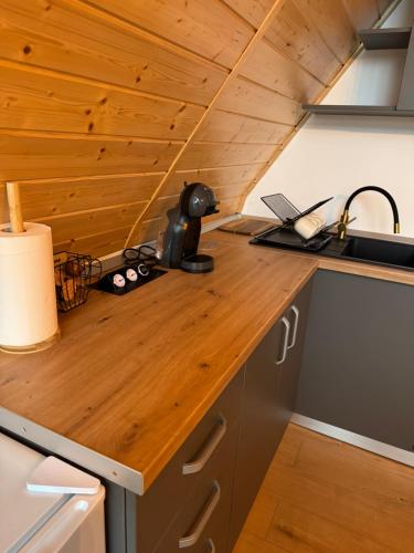 a kitchen with a wooden counter top in a tiny house at Cabana Bucegi View A-Frame Bran in Predeluţ
