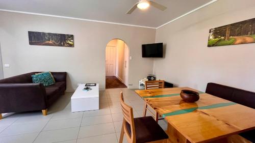 a living room with a wooden table and a couch at Channers on Norfolk in Burnt Pine
