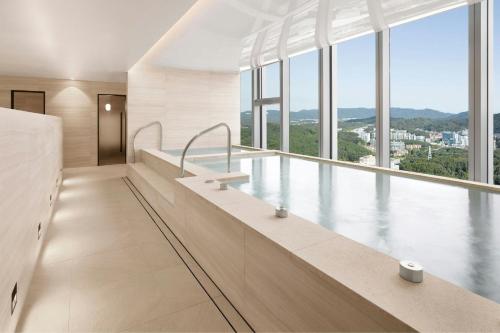 a large bath tub in a large room with windows at Hotel Onoma Daejeon, Autograph Collection in Daejeon