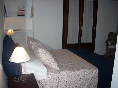 a bedroom with a bed with pillows and a lamp at La Venta del Arriero in Retuerta de Bullaque