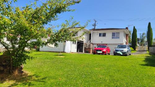 a house with a red car parked in a yard at 伯爵山庄 in Auckland