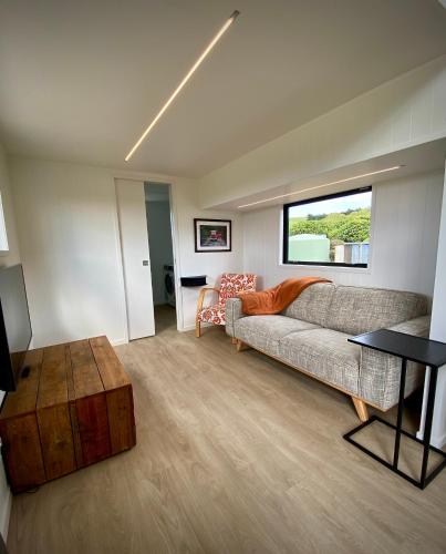 a living room with a couch and a table at Seaspray Cabin in Hinahina