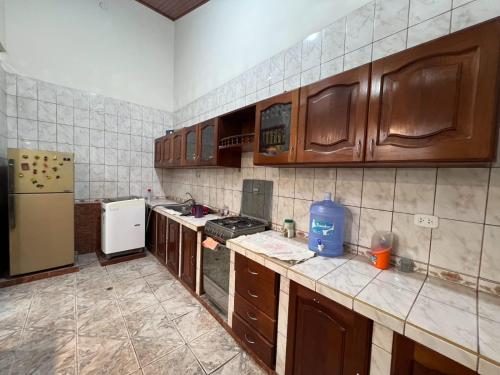 a kitchen with wooden cabinets and a white refrigerator at La Casa Verde in Iquitos