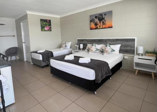 a hotel room with two beds and a table at Spanish Lace Motor Inn in Townsville